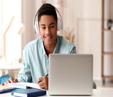 African-American guy studying online at home