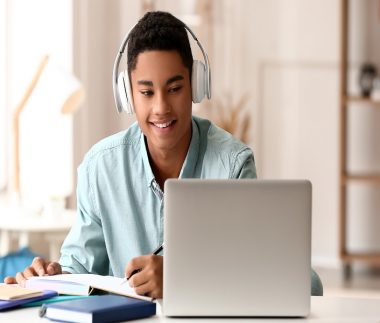 African-American guy studying online at home